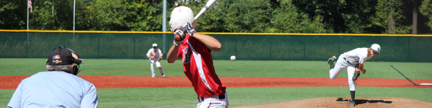 Pitcher throws baseball and batter is ready to take a swing at baseball field at Eastlake Community Fields.