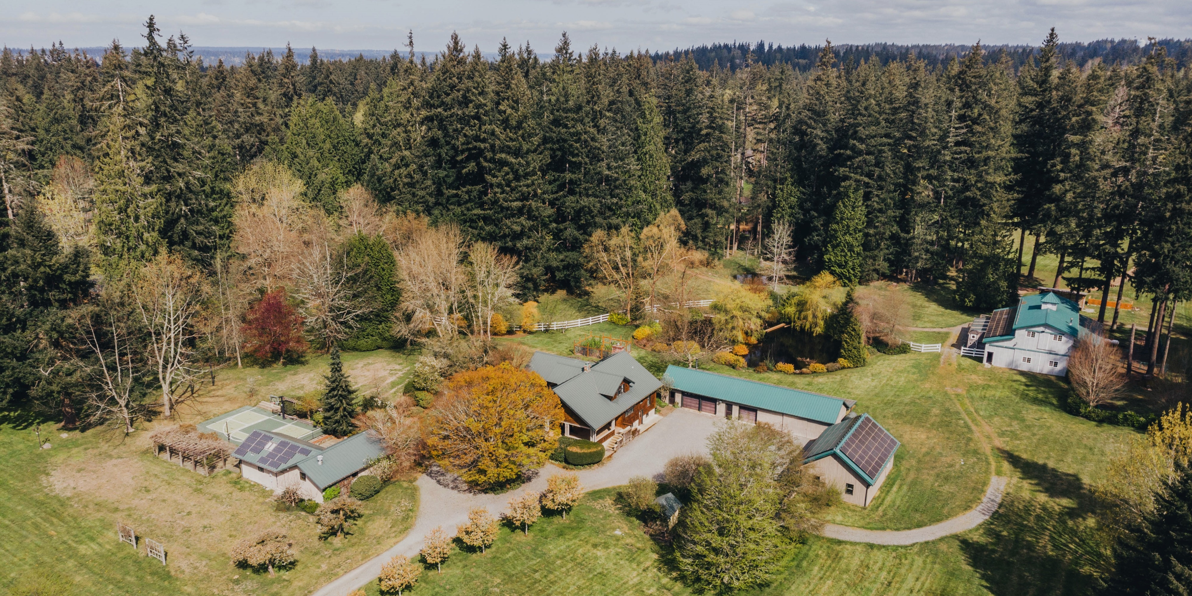 Aerial photo of Big Rock Park South showing several buildings with solar panels and bright autumn foliage before conifer forest