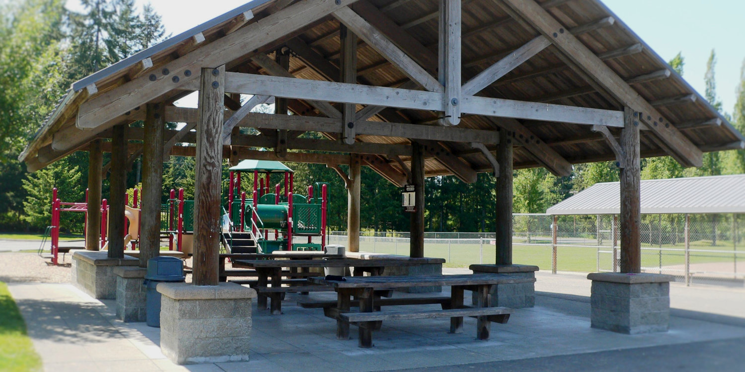 Beaver Lake Picnic Shelter with children's playground and sports fields in the background.